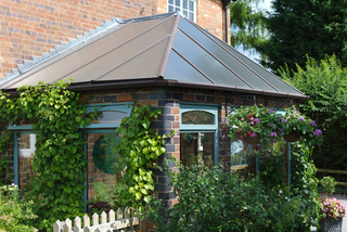 Conservatory covered in shrubs and climbing garden plants